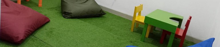 Ruang kelas dengan rumput sintetis dan meja kecil