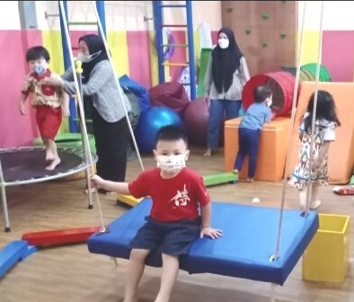 Anak-anak bermain ayunan di ruang sensori integrasi