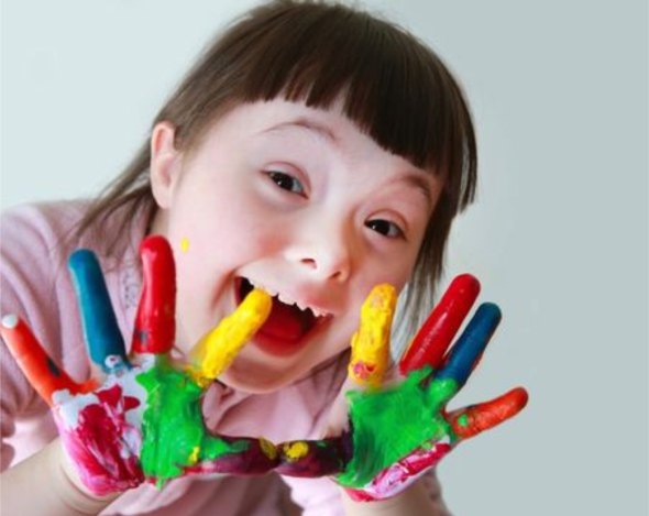 Anak tersenyum ceria dengan tangan penuh cat warna-warni